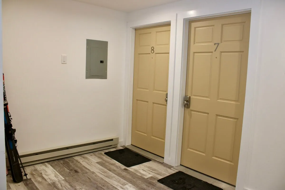 An inviting entryway with doors numbered 7 and 8, featuring warm flooring and a utility panel. The space feels welcoming, suggesting easy access and secure entry, ideal for greeting guests or returning from a day outdoors.